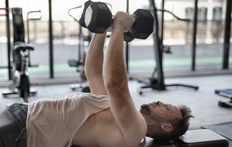 man-doet-krachttraining-op-fitnessbank-metdumbbells-chest-flies.jpg