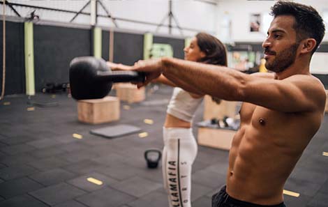 man-en-vrouw-doen-samen-krachttraining-kettlebell-swings.jpg