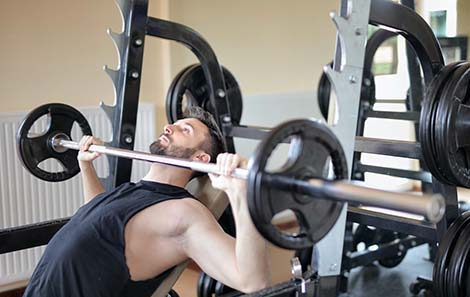 man-krachttraining-chest-press-met-halterstang-en-schijven.jpg