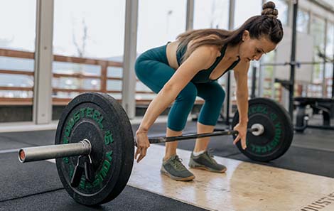 vrouw-krachttraining-met-halterstang-en-schijven-deadlift.jpg